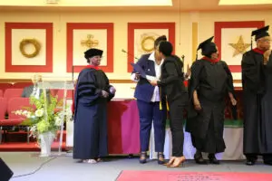 A group of people in graduation robes standing on stage.