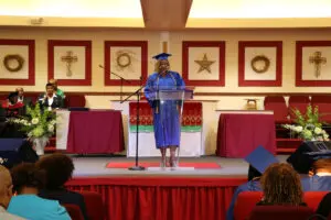 A woman giving a speech at a graduation ceremony.