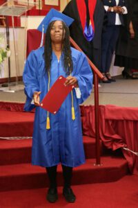 A woman in a blue graduation gown.