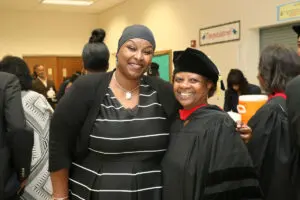 Two women posing for a photo at a graduation ceremony.
