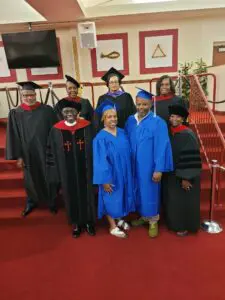 A group of people posing for a photo in graduation gowns.