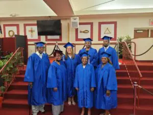 A group of people in blue graduation gowns posing for a photo.